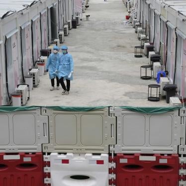 Healthcare workers walk along the makeshift Covid-19 isolation facilities in the San Tin area of Hong Kong, March 11, 2022. 