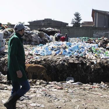 A man walks by a mound of plastic waste