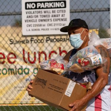 A man picks up food for his family at the Los Angeles Unified School District's Liechty Middle School in Los Angeles, California, July 16, 2021.