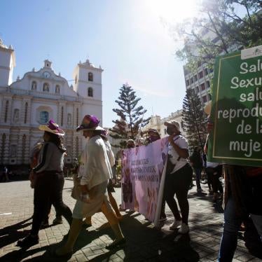 A demonstrator carries a sign reading "Women's sexual health and reproductive health" during a march to commemorate the right to vote and to celebrate the election of Honduras' first female president, in Tegucigalpa, Honduras, on January 25, 2022.