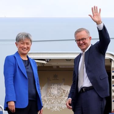 Australian Prime Minister Anthony Albanese waves alongside newly appointed Foreign Minister Penny Wong at the door of their plane