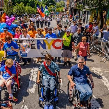 A group of parade marchers on a city street 
