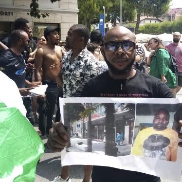 A man shows a picture of the victim Nigerian street vendor Alika Ogorchukwu