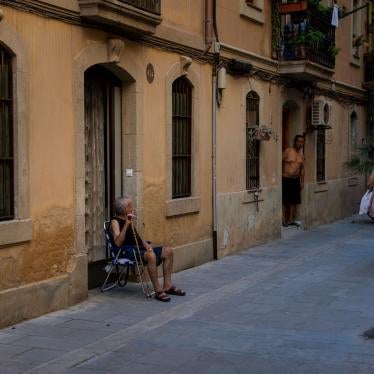 An older man sits outside his house during a heat wave in Barcelona, Spain