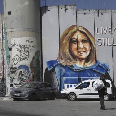 A man walks near a mural depicting slain Palestinian American journalist Shireen Abu Akleh, on Israel's controversial separation barrier in the West Bank city of Bethlehem