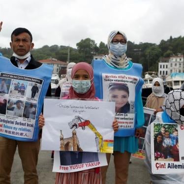 Uyghurs hold pictures of their relatives detained in China
