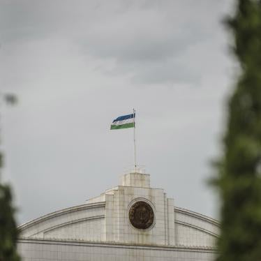 The Uzbekistan flag flies at the top of a government building