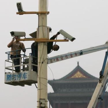 Labourers adjust newly installed surveillance cameras at Tiananmen Square ahead of National Day on September 28, 2005.