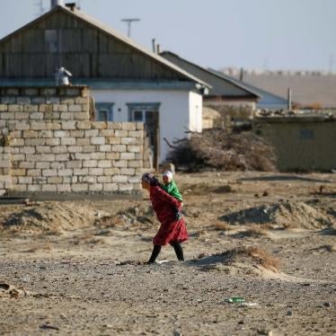A woman carries a child in the village of Zhalanash, Kazakhstan, April 16, 2017.
