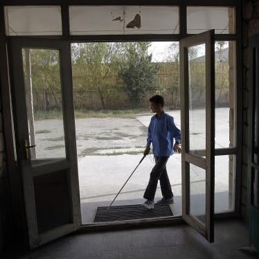 A student with a white cane arrives at a school in Kabul, Afghanistan.