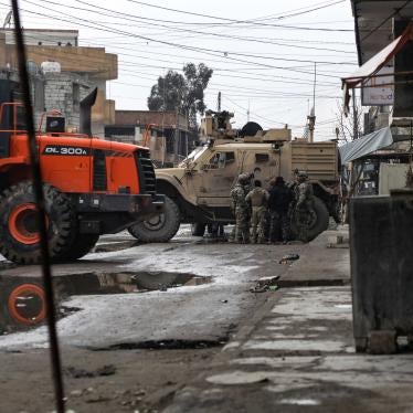US soldiers and Syrian Democratic Forces standing by loader and military vehicles in East Ghweran neighbourhood at 2 p.m. on January 29, 2022.