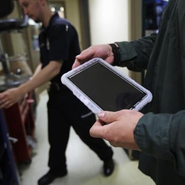A prisoner holds a tablet that he checked out from a corrections officer, left, at the New Hampshire State Prison for Men, in Concord, N.H., July 23, 2018. © 2018 Charles Krupa/AP Photo
