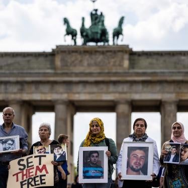 ctivists and relatives of Syrians suspected of being detained or forcibly disappeared by the Syrian government pose with portraits of missing Syrians during a demonstration in front of Berlin's Brandenburg Gate