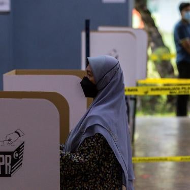 A woman casts her vote at a polling station for the 15th general election