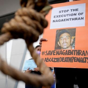 An activist holds a poster opposing the impending execution of Nagaenthran Dharmalingam