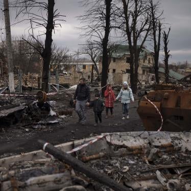 A family walks amid destroyed military vehicles in Bucha, near Kyiv, Ukraine, April 6, 2022. 