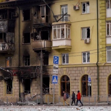People walk by a burnt out building in Mariupol, Ukraine. 