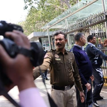 Police officers stand outside a building having BBC offices, where income tax officials are conducting a search, in New Delhi.