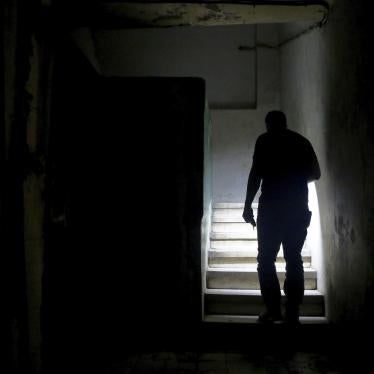 A man uses his mobile phone torch to walk up the stairs to reach his apartment