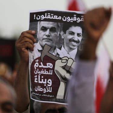 A Bahraini anti-government protester holds up a poster calling for the freedom of jailed human rights activists Nabeel Rajab (who was released in 2020), left, and Abdulhadi al-Khawaja, right, in Manama, Bahrain, May 1, 2015.