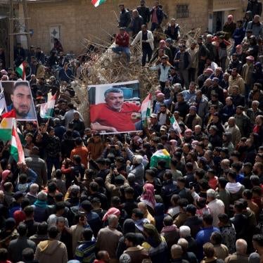 Syrian Kurds hold up pictures of two of the victims killed at the hands of Turkish-backed fighters during protests in Jinderis. 