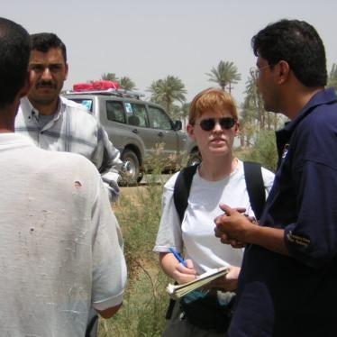Interpreter Razzaq al-Saiedi (right) and Bonnie Docherty (left) interview Iraqis affected by cluster munitions near al-Hilla in May 2003. 