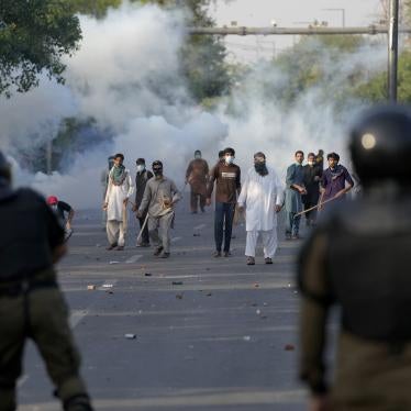 Supporters of Pakistan's former Prime Minister Imran Khan throw stones after police fire tear gas to disperse them protesting against the arrest of Khan in Lahore, Pakistan.