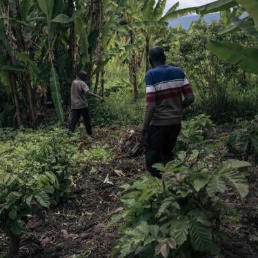 Deux hommes indiquent l’emplacement d’une fosse commune parmi des bananiers près de l’église adventiste, le 5 avril 2023. Plusieurs personnes ont été exécutées à proximité de l’église par le M23 en novembre 2022 à Kishishe, dans l’est de la République démocratique du Congo. 