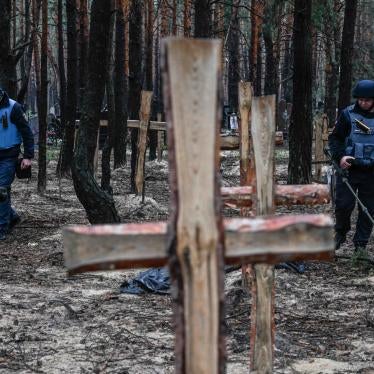 Ukrainian military personnel search for land mines at a burial site in a forest on the outskirts of Izium, eastern Ukraine, September 16, 2022. 