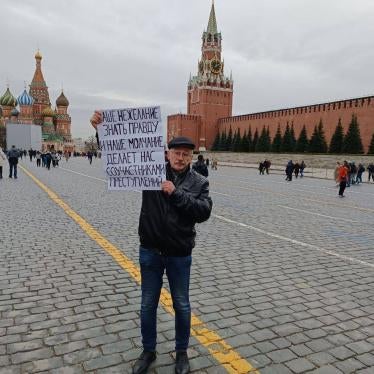 Oleg Orlov protesting Russia's abusive war in Ukraine at the Red Square in Moscow, April 2022. His poster reads, 'Our unwillingness to know the truth and our silence turn us into collaborators in crimes.’