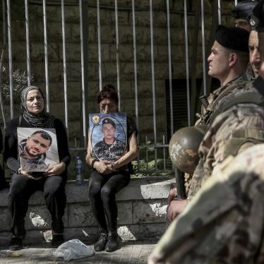 Families of the victims of the Beirut port blast hold pictures of their loved ones near Lebanese soldiers during a protest outside of the Beirut court, September 27, 2022. 