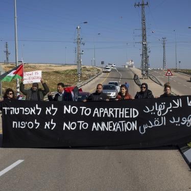 Israeli and Palestine activists hold a banner during a protest to block the new Route 4370 Israeli highway near the Palestinian town of Anata, January 23, 2019.