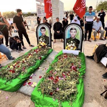People gather around the symbolic graves of Jaafar Sultan (left) and Sadeq Thamer