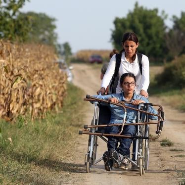 Nujeen, a wheelchair user, and her sister travel down a dirt path after fleeing their native Syria. 