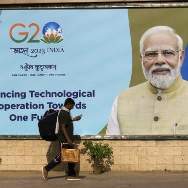 A migrant laborer walks past a billboard ahead of the summit of the Group of 20 nations in New Delhi, September 4, 2023.