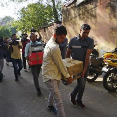 Security officers carry boxes of material confiscated after a raid at the office of NewsClick in New Delhi, India, October 3, 2023. 