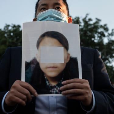 An activist holds a picture of an alleged young North Korean refugee during a demonstration calling on Chinese President Xi Jinping to allow safe passage to North Koreans detained in China, across the street from the Chinese embassy in Washington, DC, September 24, 2021. 