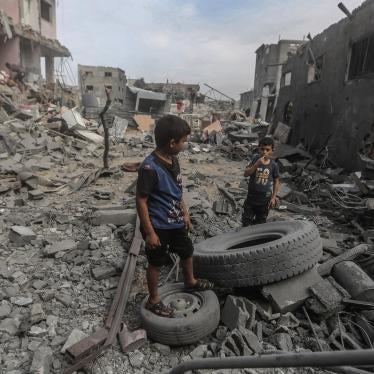 Palestinian children stand amid the rubble of destroyed buildings in Al-Bureij camp, Gaza