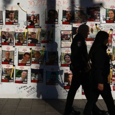 People pass by portraits of Israeli hostages from Israel held in Gaza since the October 7 attacks in Tel Aviv, December 17, 2023. 