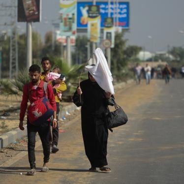 A woman holds a white flag while evacuating with other Palestinian civilians towards the southern Gaza Strip, November 7, 2023.