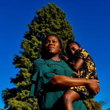 A woman poses for a photo holding her son