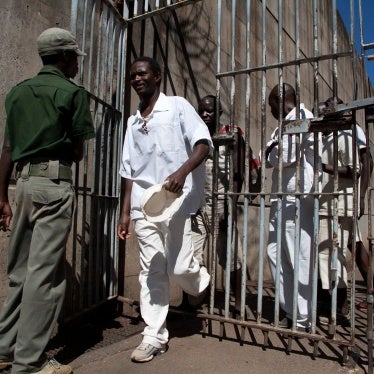 Inmates walk past a prison guard at the Chikurubi maximum security prison in Harare, Zimbabwe, May 20, 2015.