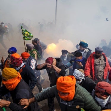 Protesting farmers flee exploding tear gas shells.