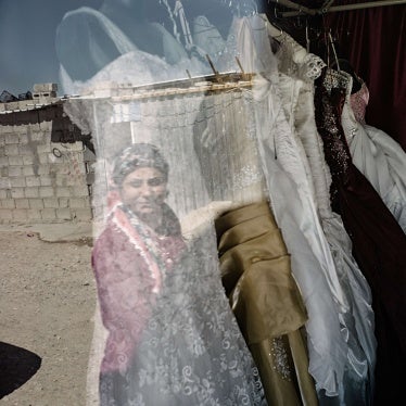 A woman looks at wedding dresses in a store window
