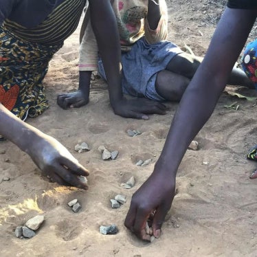 Figures' hands lay in the sand.