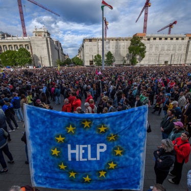 A protester holds up an EU flag with "help" written on it, during a demonstration in Budapest on May 18, 2025 against a bill empowering the government to sanction civil society organizations and media it deems threats to the country's sovereignty.