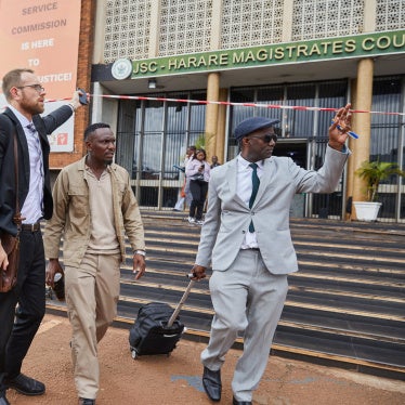 Zimbabwean journalist and his lawyers leave a Magistrate's court