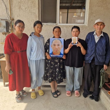 Family members and neighbor (far right) of Alimnur Turganbay, a Kazakhstan citizen detained in China, outside their house in Uzynagash village, located outside Almaty, Kazakhstan on August 4, 2025.