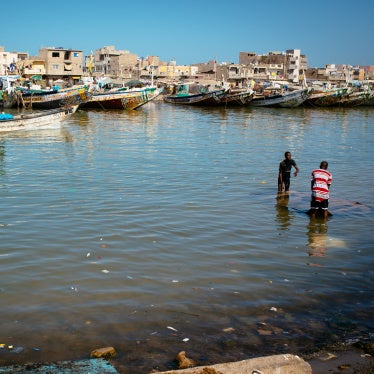 Two people working on a sunken boat  in the Langue de Barbarie, Saint-Louis, Senegal, March 7, 2023. 