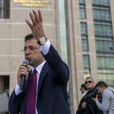 A man speaking into a microphone in front of a courthouse